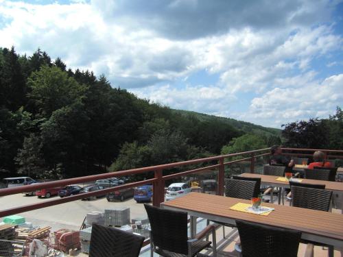a balcony with a table and chairs and a view of a parking lot at Wald-Hotel Heppe in Dammbach