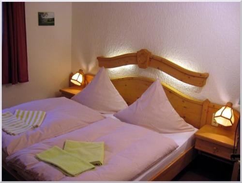 Una cama con dos servilletas verdes encima. en Gasthof-Pension Rotes Haus, en Kurort Oberwiesenthal