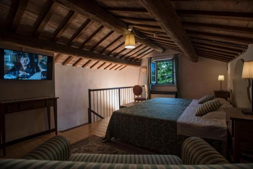 a bedroom with a bed and a flat screen tv at Ca' Virginia Country House Wellness in Montecalvo in Foglia
