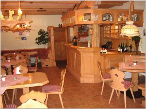 クアオルト・オーバーヴィーゼンタールにあるGasthof-Pension Rotes Hausのテーブルと椅子のあるレストラン、バー