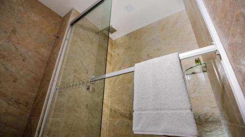 a shower with a glass door and a towel at Life Hotel in Oaxaca City