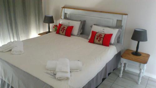 a bedroom with a large white bed with red pillows at NO. 2 Avignon in Margate