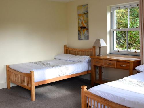 a room with two beds and a desk and a window at Rivers Bend Cottage in Skull