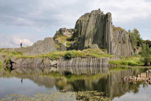 a large rock formation next to a body of water at Apartmán U Mluvících Kamenů in Staré Křečany