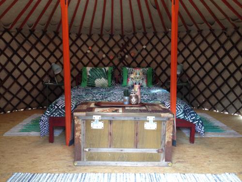 卡塔馬的住宿－法哈拉莊園露營地，圆顶帐篷内的一张床位,配有木桌