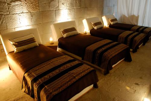 a group of three beds in a room with lights at Xima Exclusive Cusco in Cusco