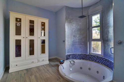 a large bathroom with a tub and a window at AlmenaraLove Bellaluna in Robledo de Chavela