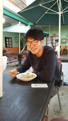 a man sitting at a table with a plate of food at Hierba De Conejo Hostel in Oaxaca City