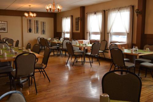 a dining room with tables and chairs and windows at Hotel Port Aux Basques in Channel-Port aux Basques
