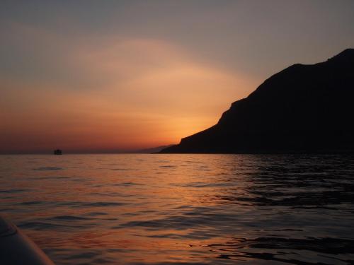 a sunset from a boat in the water at Samaria in Agia Roumeli