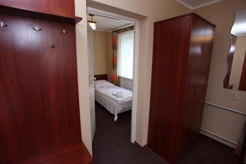 a small room with a bed and a closet at Hotel Kakadu in Konin