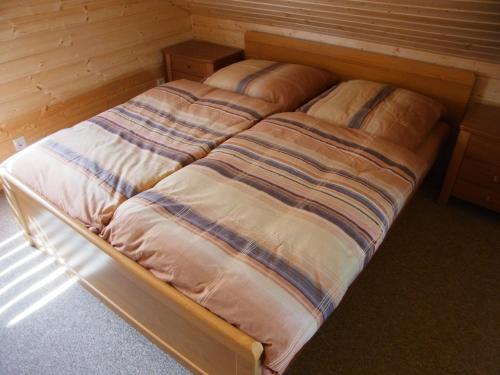 1 cama no hecha en una habitación con paredes de madera en Ferienhaus Franziska, en Kołobrzeg