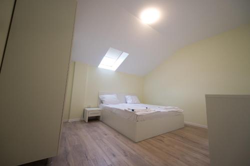 a bedroom with a bed in a room with a skylight at Gaga Residence 13 in Timişoara