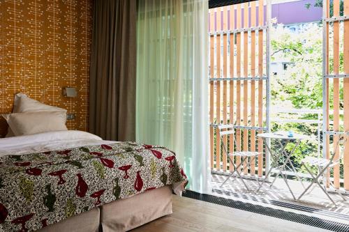 1 dormitorio con 1 cama y ventana con patio en Eden Lodge Paris, en París