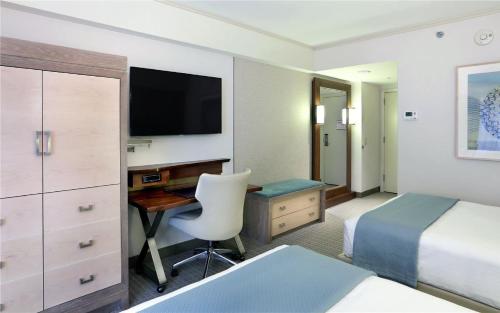 a hotel room with a bed and a desk and a television at Seaport Hotel® Boston in Boston