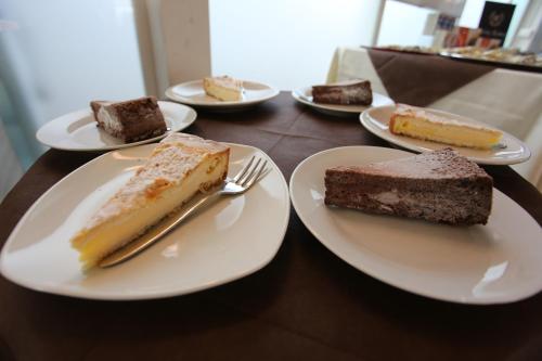a table with plates of desserts on them at Hotel Eubea in Reggio Calabria