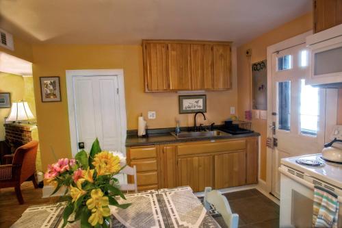 a kitchen with a sink and a table with a vase of flowers at St. Francis Inn - Saint Augustine in Saint Augustine
