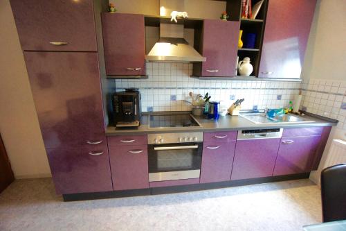ベルンカステル・クースにあるFerienwohnung Michelsのキッチン(紫色のキャビネット、シンク付)