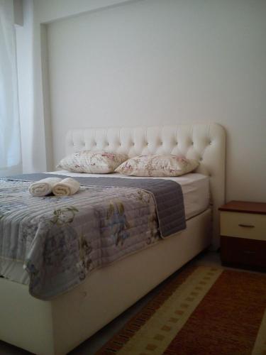1 dormitorio con 1 cama con cabecero blanco y almohadas en C.C HOME SUİT APART, en Edirne