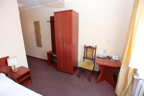 a bedroom with a desk and a bed and a cabinet at Hotel Kakadu in Konin
