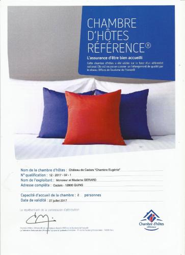a sign for a bed with a red pillow and three blue pillows at Chateau de Cadars in Quins