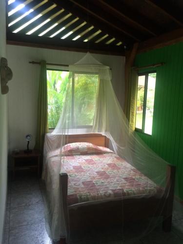 a bedroom with a bed with a mosquito net at Hotel Suizo Loco Lodge & Resort in Cahuita