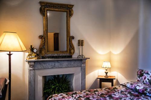 a living room with a fireplace and a mirror at Hotel Santa Caterina in Siena