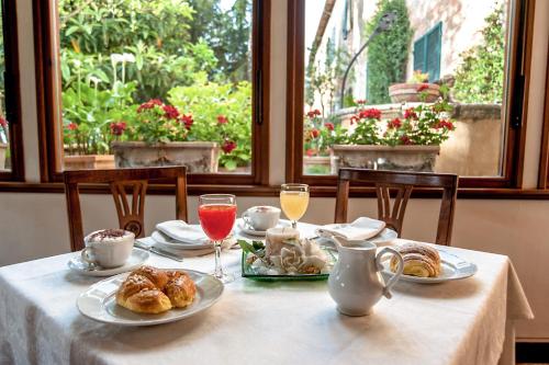 a table with plates of pastries and glasses of wine at Hotel Santa Caterina in Siena