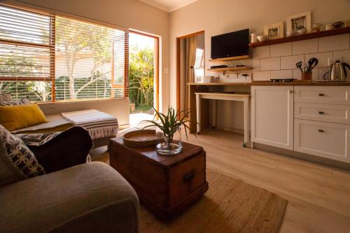 uma sala de estar com um sofá e uma mesa em Treehouse at Theebos em Strand