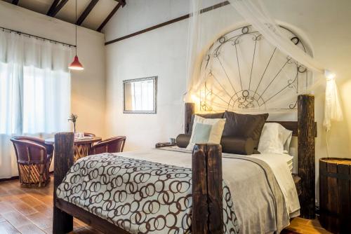 a bedroom with a large bed and a dining room at Terra del Valle Bed & Breakfast in Valle de Guadalupe