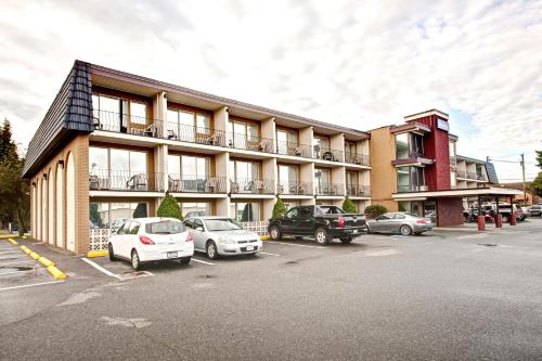 a building with cars parked in a parking lot at Travelodge by Wyndham Nanaimo in Nanaimo