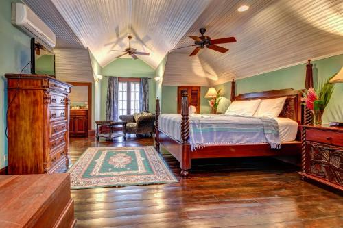 Toucan Suite @ Mahogany Hall في سان إجناسيو: غرفة نوم بسرير ومروحة سقف