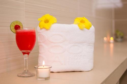 ein Getränk und eine Kerze auf der Theke mit einem Handtuch in der Unterkunft Hotel Altamar Cartagena in Cartagena de Indias