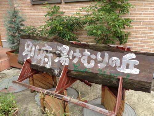 a wooden sign with asian writing on it at Beppu Yukemuri-no-oka Youth Hostel in Beppu