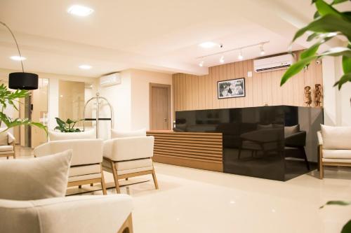 a living room with white chairs and a fireplace at Paracambi Top Hotel in Paracambi