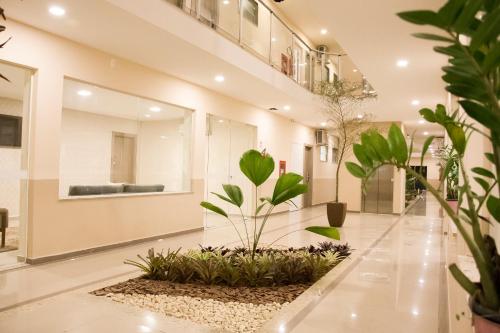 a lobby with plants on the floor at Paracambi Top Hotel in Paracambi