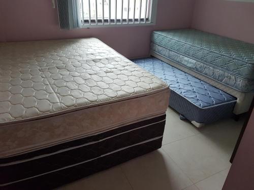 two beds sitting next to each other in a room at Novo Lar 1 Bombinhas (Eliseos) in Bombinhas