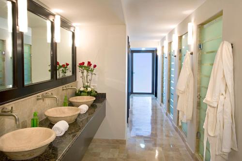 馬薩特蘭的住宿－Las Villas Hotel & Golf By Estrella del Mar，一间带两个盥洗盆和走廊的浴室