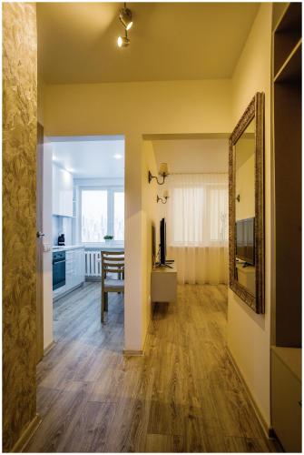 a living room with a mirror and a television at Apartments Meskos Guolis in Telšiai