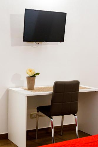 a desk with a chair and a monitor on a wall at B&B Stella Maris Sciacca Centro in Sciacca