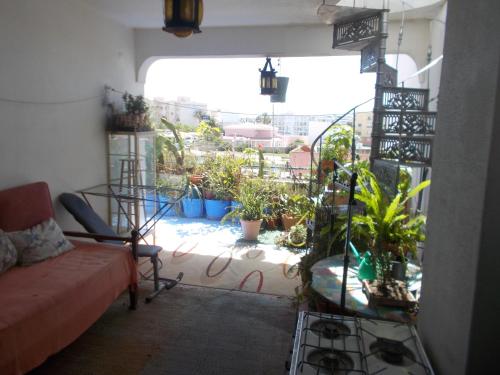 a living room with a couch and a balcony with plants at ztiR in Olhão