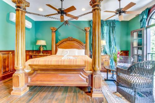 a bedroom with a wooden bed in a room with green walls at Family Suite @ Mahogany Hall in San Ignacio
