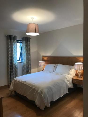 - une chambre avec un grand lit blanc et deux lampes dans l'établissement Holiday Home On Farnham Estate, à Cavan