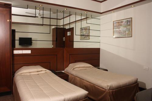 a waiting room with two beds and a tv at Hotel Karl Residency in Mumbai