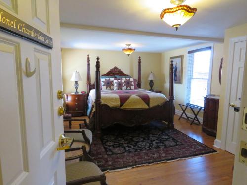 a bedroom with a bed and a chair in a room at The Swope Manor Bed & Breakfast in Gettysburg