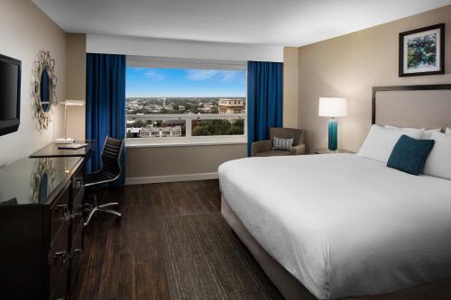 a hotel room with a bed and a large window at The DeSoto in Savannah
