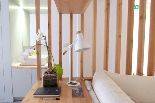 a table with a lamp and a laptop on it at Pelago Houses in Ponta Delgada