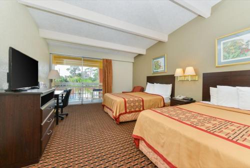 Americas Best Value Inn Sarasota في ساراسوتا: غرفة فندقية بسريرين وتلفزيون بشاشة مسطحة