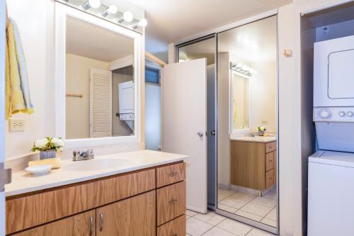 a bathroom with a sink and a refrigerator at Waikiki Shore 305 (beachfront/balcony) in Honolulu