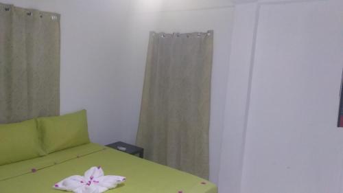 a room with a green bed with a flower on it at Caribbean Dream Vacation Property CD2 in Rodney Bay Village